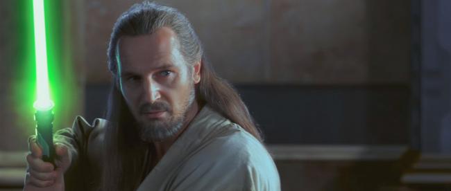 Liam Neeson als Qui-Gon Jinn mit erhobenem Lichtschwert